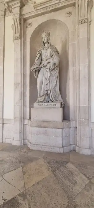 Marmurowa statua królowej Izabeli I stoi na straży przy drzwiach Kaplicy Królewskiej w madryckim Palacio Real.